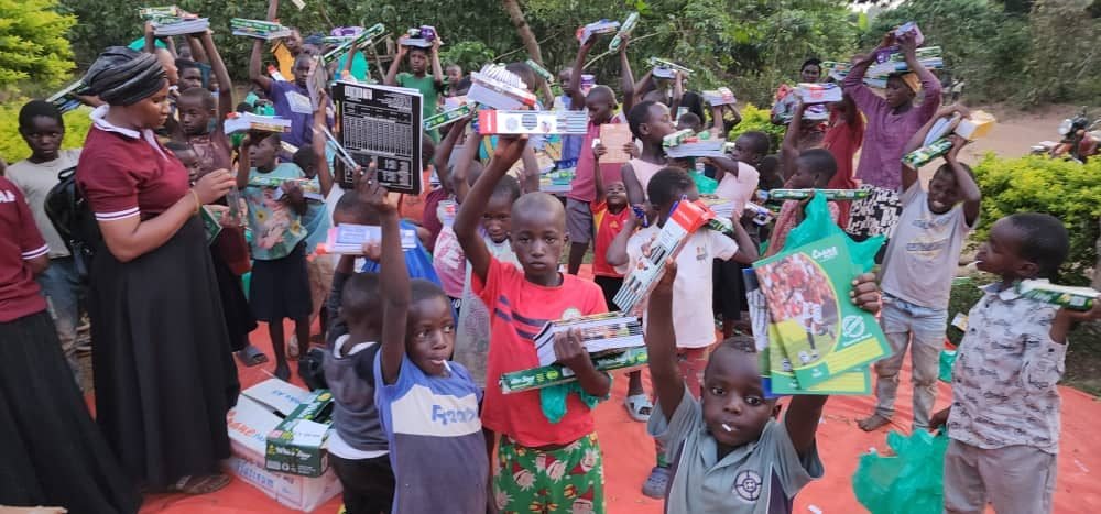 Niños de Wobulenzi levantando material escolar